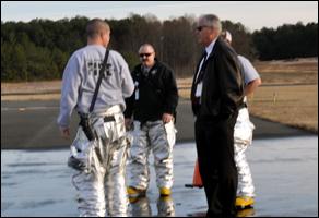 Fire Engineers Justin Graney, Trevor Beyma and David Robbins talk with Deputy Airport Director of Operations Mike McElvaney during a training drill.